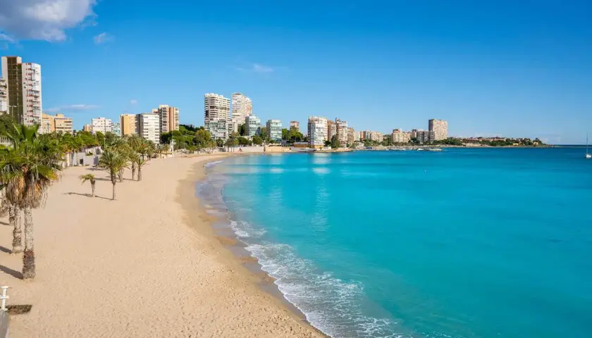 Playa de Oropesa del Mar con edificios y palmeras. Imagina tomar el tren Madrid Oropesa del Mar para llegar a este paraíso.