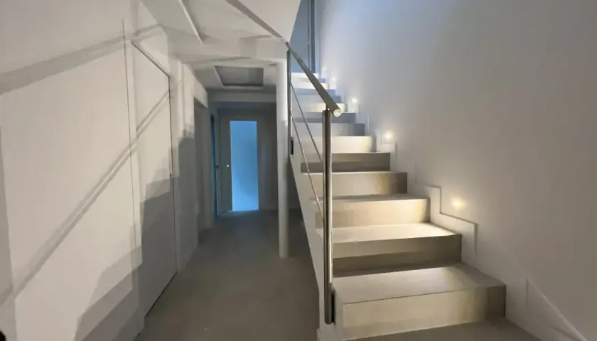 Iluminación peldaños escalera moderna, con luces empotradas que guían el camino.