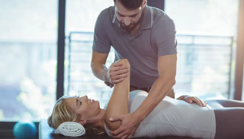Fizjoterapeuta wykonuje ćwiczenia z pacjentką. Rehabilitacja i fizjoterapia pomagają w powrocie do zdrowia.