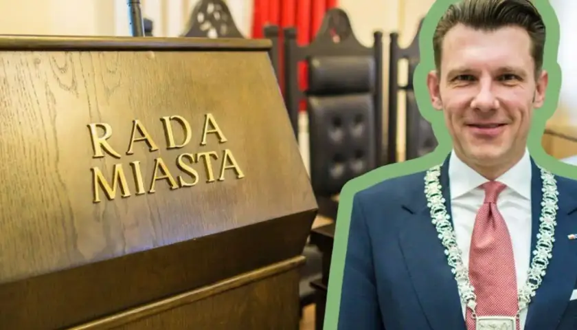 Burmistrz w garniturze i łańcuchu z herbem, na tle sali obrad Rady Miasta. Ciekawe, ile zarabia burmistrz?
