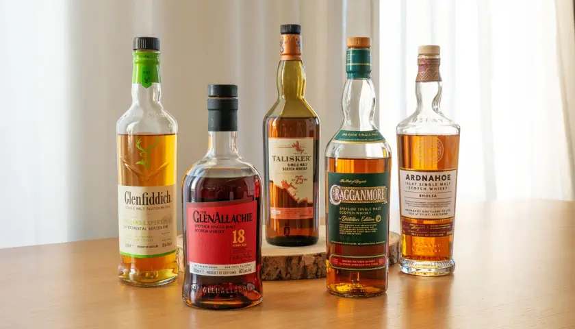 Fünf Flaschen verschiedener Whisky-Sorten stehen nebeneinander: Glenfiddich, Glenallachie, Talisker, Cragganmore und Ardnahoe.