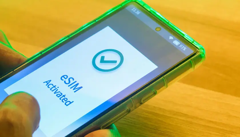 Smartfon z zieloną obudową pokazuje komunikat "eSIM Activated" i zielony znaczek. Tak działa esim.