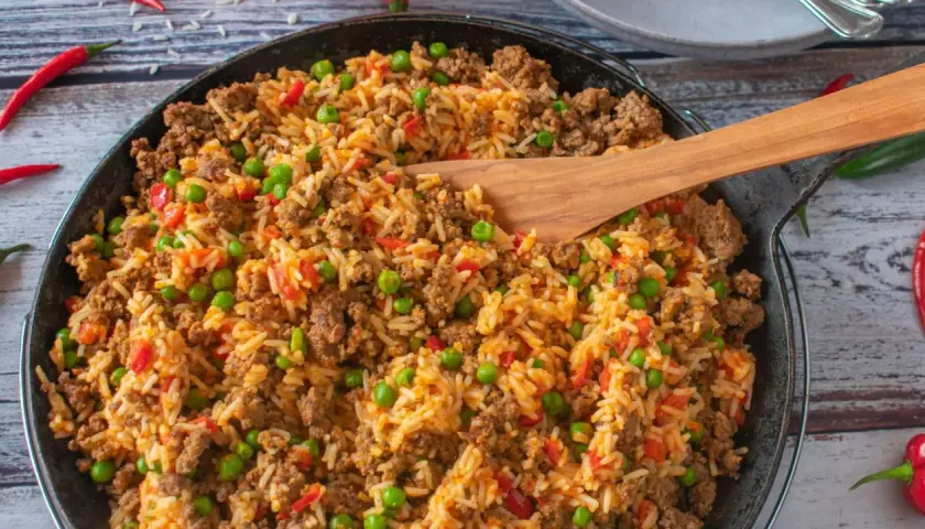Herzhafte hackfleisch reis pfanne mit Erbsen und Paprika, garniert mit Chilischoten. Ein köstliches Gericht für die ganze Familie.