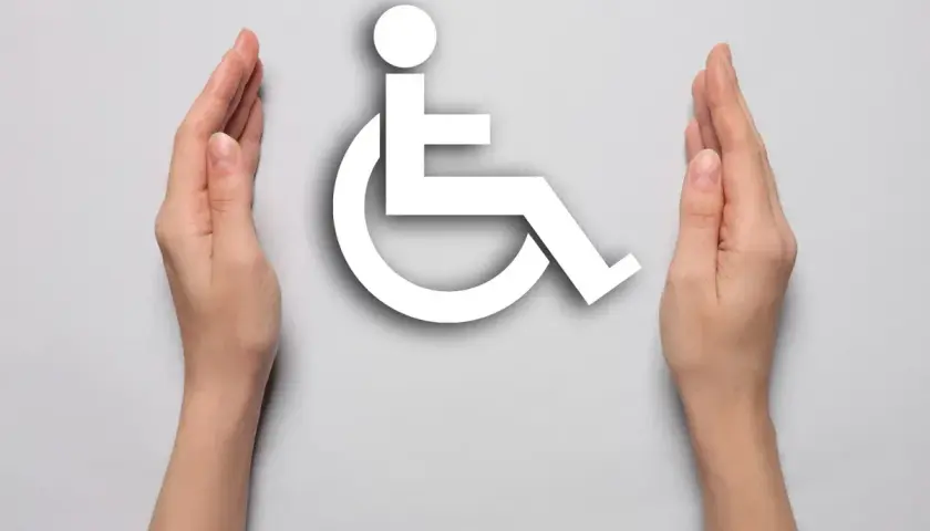 Symbol wózka inwalidzkiego otoczony dłońmi. Symbolizuje wsparcie dla osób z niepełnosprawnością, np. po mastektomii.