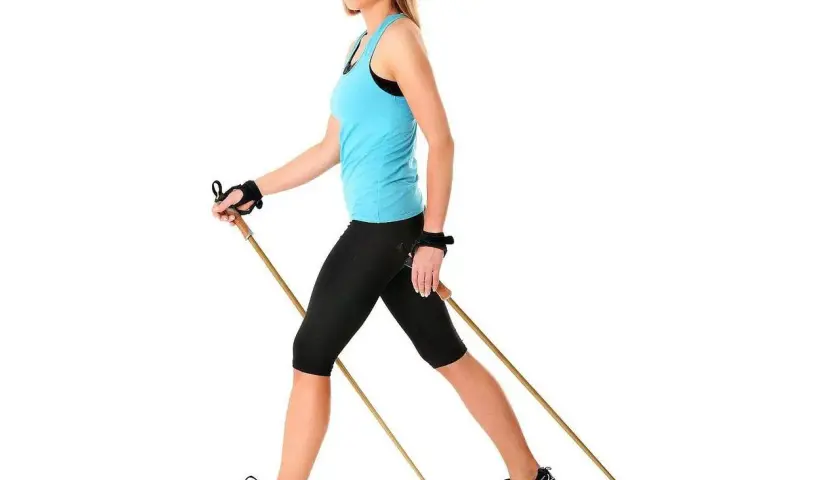 Kobieta ćwiczy nordic walking, pokazując, jak dobrać kije.