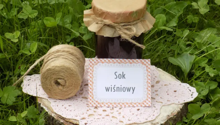 Sok z wiśni przepis: słoik domowego soku, sznurek i serwetka na pniu drewna. Idealny na lato!