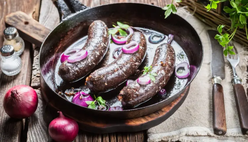 Boudin noir poêlé avec oignons rouges. Astuce pour comment cuire le boudin noir sans qu'il éclate : le piquer légèrement avant cuisson.