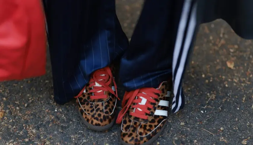 Zapatillas tendencia con estampado de leopardo y cordones rojos, combinadas con pantalones de raya diplomática.