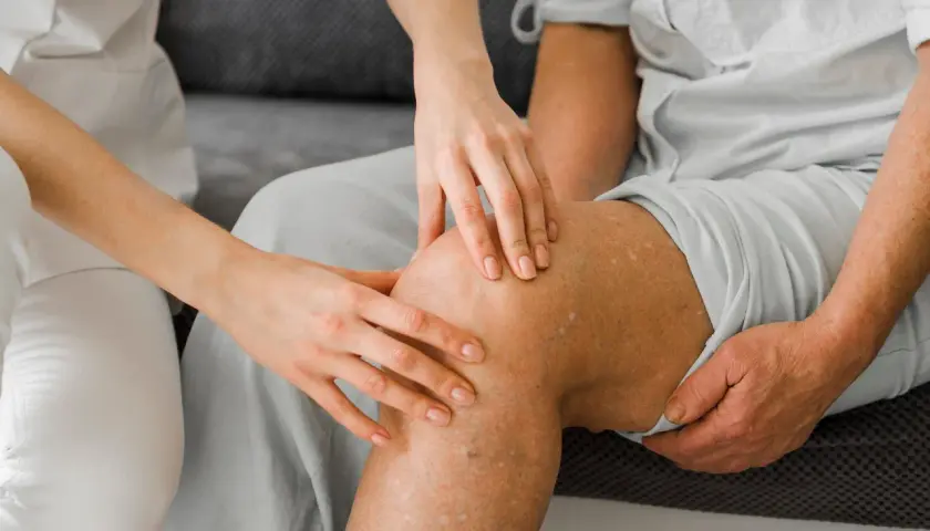 Ärztin untersucht Knie, um runners knee symptome zu identifizieren.