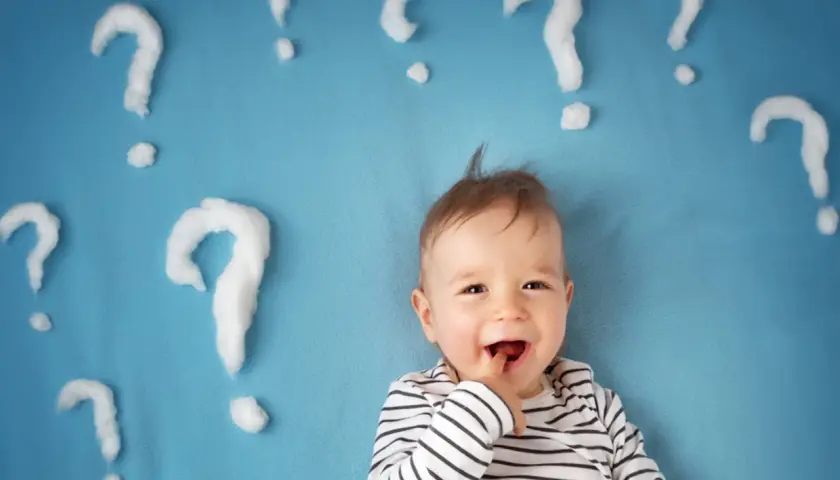 Un neonato sorridente con tante domande intorno. Quante volte fa la cacca un neonato di 1 mese?