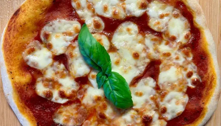 Eine köstliche italienische Sauerteig Pizza Margherita mit geschmolzenem Mozzarella und frischem Basilikum.