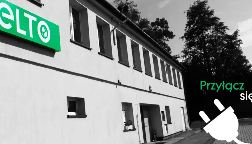 Hurtownia elektryczna ELTO zaprasza do przyłączenia się. Zielone logo ELTO na budynku i wtyczka symbolizują energię.