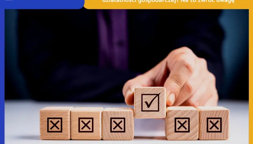 Dłoń układa kostki z symbolami. Jedna z nich, z zaznaczonym ptaszkiem, symbolizuje sukces w jdg.