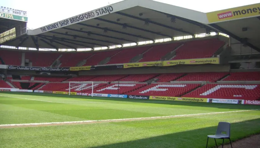 Puste trybuny stadionu Nottingham Forest, z widocznym napisem "The Money Shop Bridgford Stand".