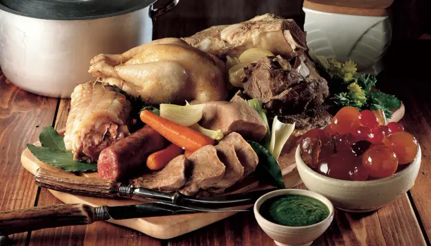 Un ricco bollito con mostarda, composto da pollo, lingua, salumi e verdure, pronto per essere gustato.