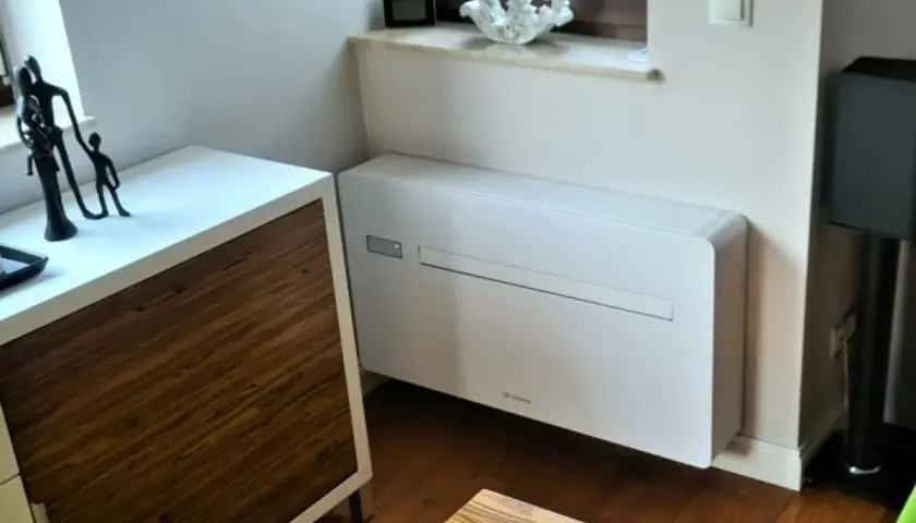 Nowoczesny klimatyzator bez jednostki zewnętrznej, dyskretnie wkomponowany w eleganckie wnętrze.