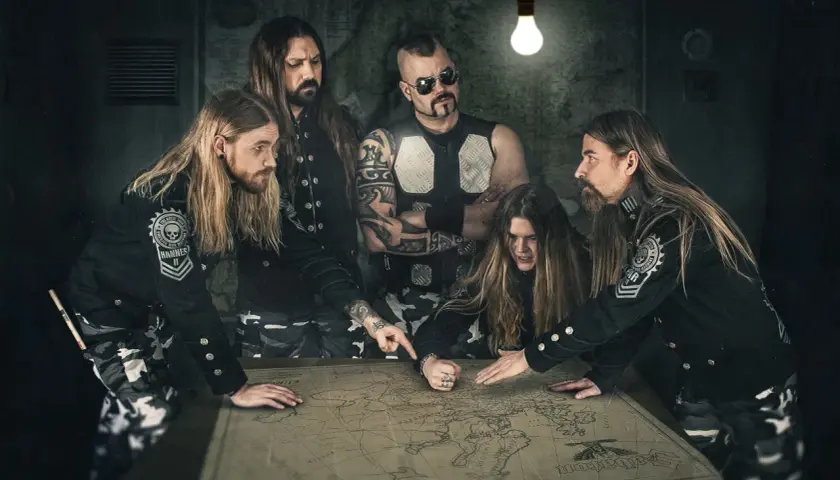 Zespół Sabaton, niczym skrzydlaci husarze, planuje strategię na mapie.