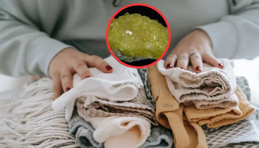Manos doblando ropa limpia, con una piedra amarilla brillante que evoca el olor a mercaptano.