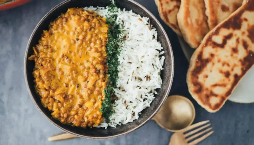 Herzhaftes veganes Linsendal mit Basmatireis und Fladenbrot.