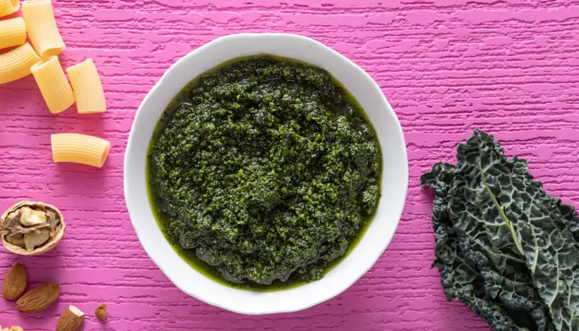 Pesto di cavolo nero crudo, ricco e vibrante, pronto per condire la pasta. Noci e mandorle completano gli ingredienti.
