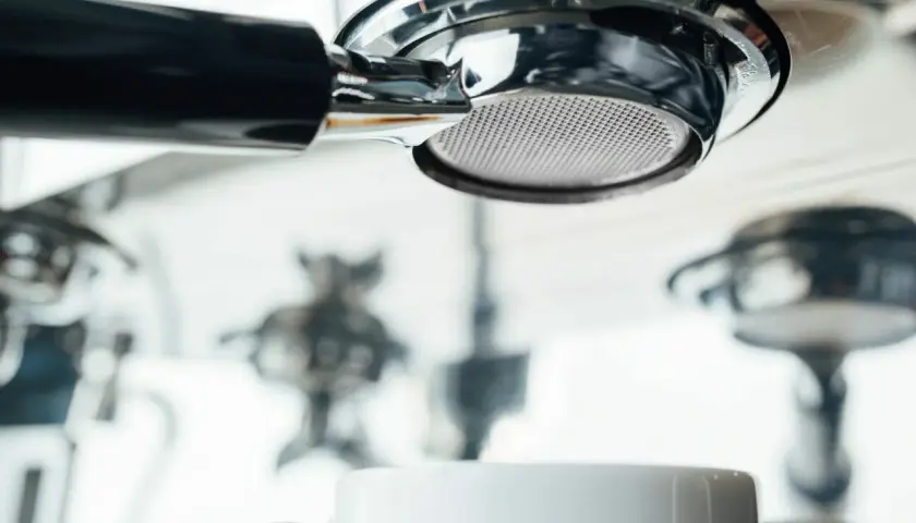 Filtr ekspresu DeLonghi, biała filiżanka i inne elementy. Zbyt częste odkamienianie ekspresu Delonghi może prowadzić do jego uszkodzenia.