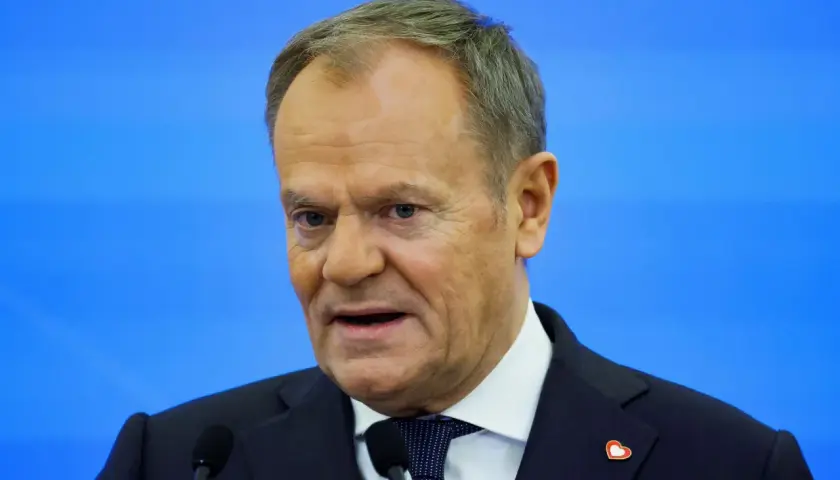 Donald Tusk, w garniturze i z serduszkiem na klapie, przemawia. Zastanawiamy się, co zrobił Tusk dla Polski.