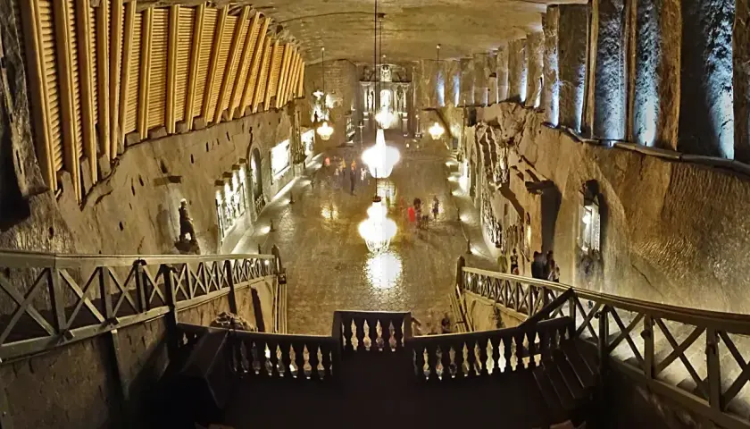 Wieliczka wycieczka: podziemna kaplica z kryształowymi żyrandolami i rzeźbami w soli. Widok z góry na schody i balustrady.