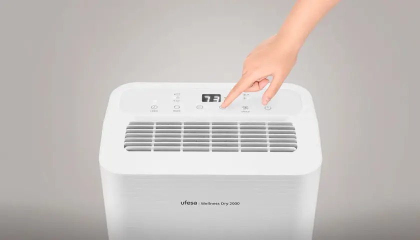 Mano ajustando el control de un deshumidificador Ufesa Wellness Dry 2000. Este deshumidificador sirve para controlar la humedad del ambiente.