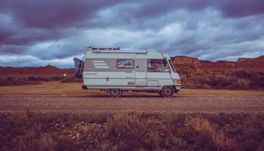 Camping-car Hymer B544, prêt pour l'aventure dans un paysage désertique sous un ciel orageux.