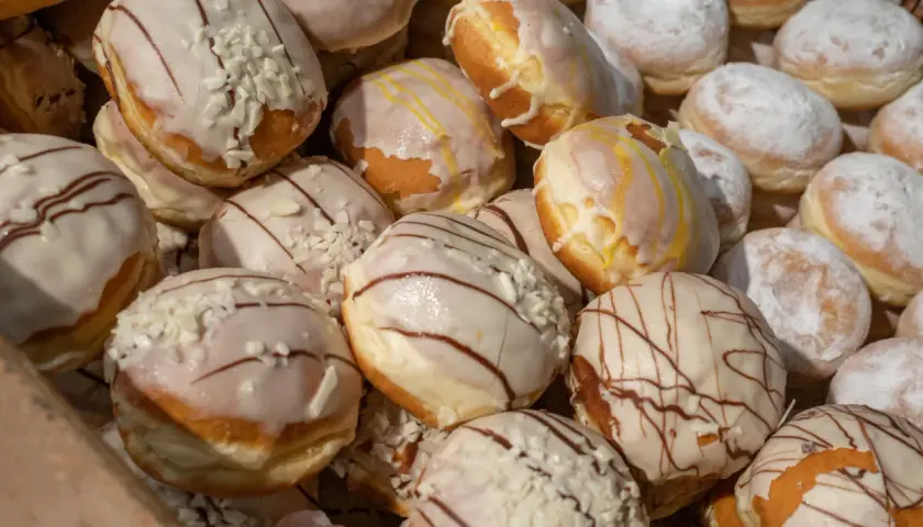 Pączki z lukrem i posypką, niektóre z polewą czekoladową. Czy paczki można mrozic? Tak, można je zamrozić, by cieszyć się nimi dłużej.