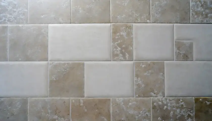 Pareti con piastrelle rettificate e fuga minima. Diverse tonalità di beige e bianco creano un motivo moderno e pulito.