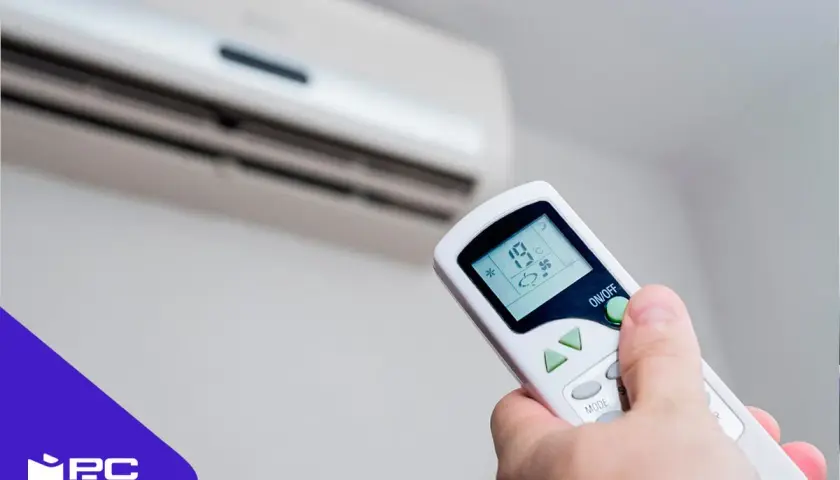 Mando a distancia ajustando el aire acondicionado a 19°C para disfrutar del frío.