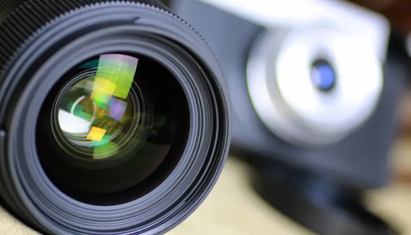 Obiektyw aparatu z widocznymi odbiciami, gotowy do uchwycenia wyjątkowych chwil. To symbol akredytacji fotograficznej.