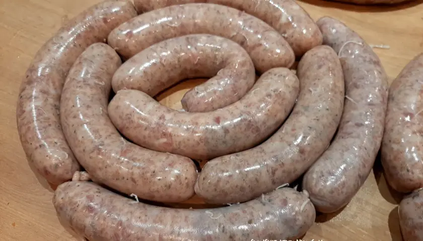 Świeża biała kiełbasa ułożona w okręgu, gotowa na przepis na 3 kg. Idealna na świąteczny stół.