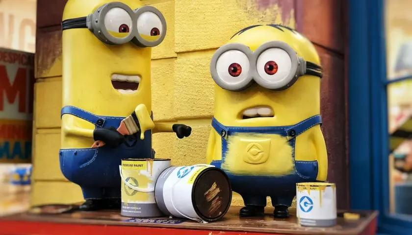 Dwa Minionki malują pędzlem. Jeden z nich ma otwarte usta, drugi wygląda na zaskoczonego. To inspiracja, jak zrobić strój Minionka!