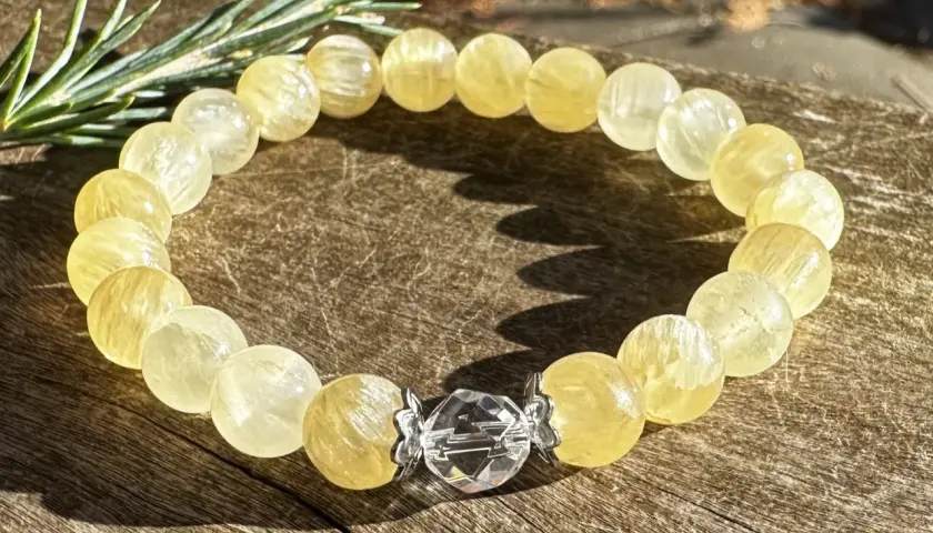 Armband aus gelben Calcit-Kugeln mit einem Kristall-Verschluss. Der Danburit Heilstein Wirkung wird oft mit Klarheit und Energie assoziiert.