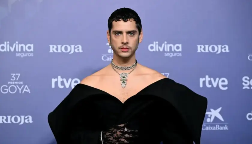 Eduardo Casanova, con un elegante vestido negro y joyas deslumbrantes, posa en la alfombra roja de los Goya.