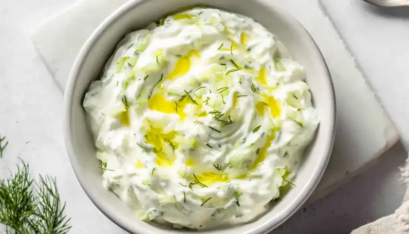 En skål med krämig tzatziki creme fraiche, toppad med olivolja och dill. Perfekt till grillat eller som dipp.