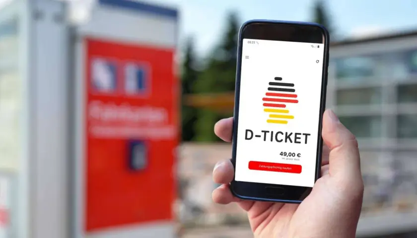 Smartphone zeigt D-Ticket App mit Preis und Kaufbutton. Verschiedene Deutschlandticket zahlungsarten sind möglich.