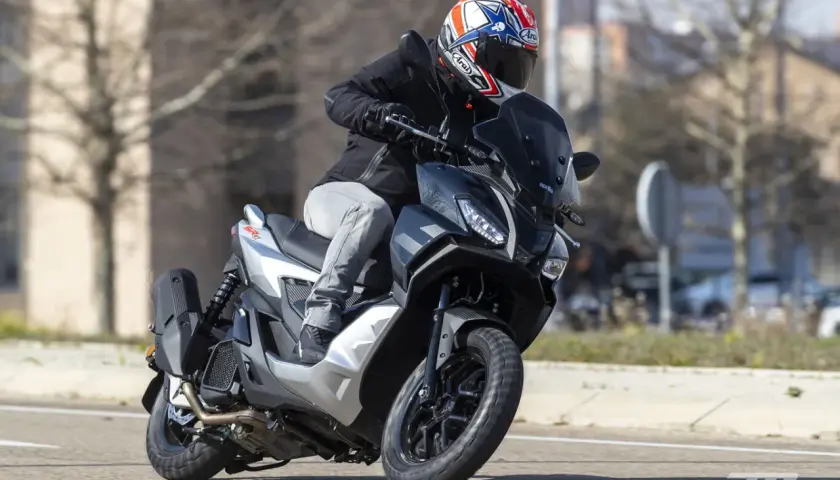 Motorista con casco a bordo de una Aprilia SR GT 125, lista para alcanzar su velocidad máxima en la carretera.