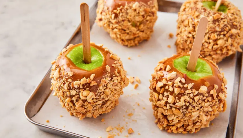 Manzanas acarameladas cubiertas de cacahuetes, perfectas para recetas con manzanas.