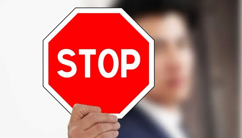Mężczyzna trzyma czerwony znak stop.