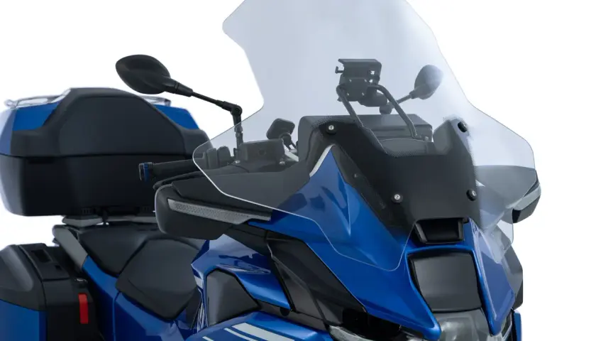 Cupolino trasparente per moto, con un design che ricorda un cupolino cafe racer, montato su una BMW blu con borse laterali e bauletto.