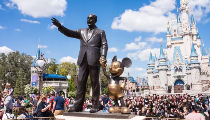 Walt Disney i Myszka Miki pozdrawiają tłumy przed zamkiem w największym Disneylandzie na świecie.