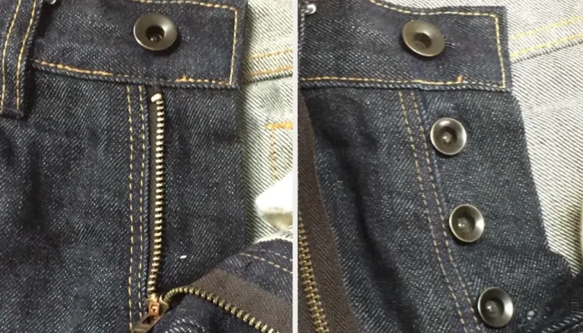 Close-up of dark wash jeans. One side shows a zipper fly with a single bouton jeans at the top. The other side displays three bouton jeans.