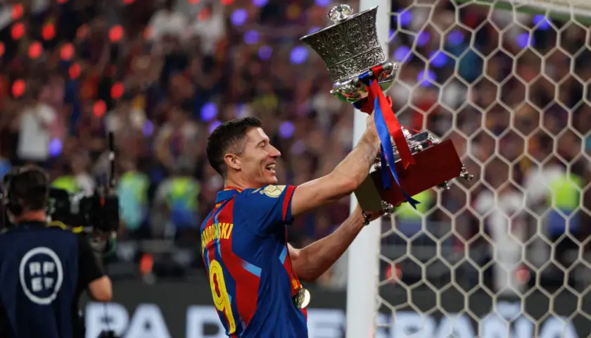 Robert Lewandowski z pucharem, symbol jego bogatej kariery. Krótka biografia tego piłkarza to historia sukcesów.