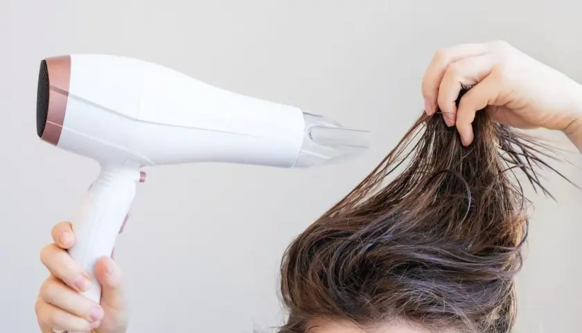 Secando el pelo mojado con un secador para dar volumen al pelo fino.
