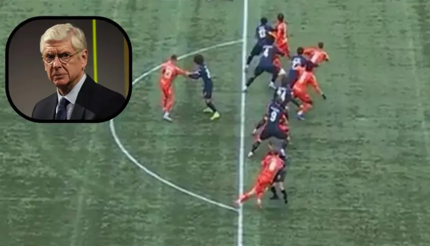 Arsene Wenger patrzy na boisko, gdzie piłkarze w czerwonych i granatowych strojach tworzą szpaler.