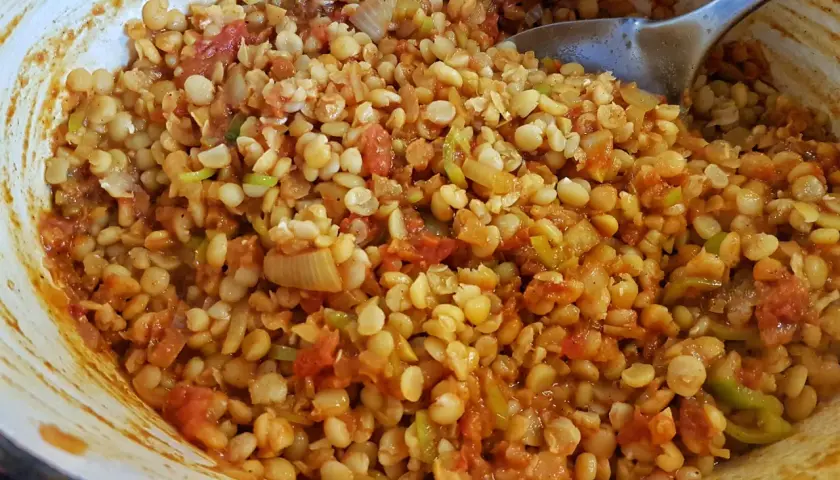 En skål med kryddig chana dal, en indisk linsrätt med tomat och lök, redo att serveras.