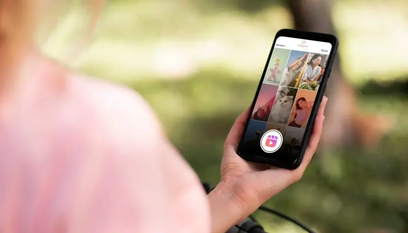 Osoba trzyma smartfon z widokiem na ekran Instagram Reels z różnymi zdjęciami.